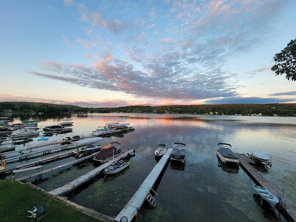 Un port de plaisance avec des bateaux amarrés, une eau calme et un coucher de soleil en arrière-plan.