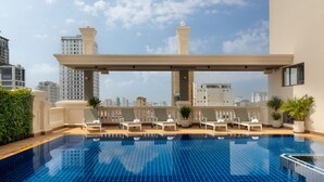 A rooftop pool with lounge chairs and a city view. - Duong Chan Hotel (Phnom Penh)
