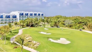 Un terrain de golf avec un bâtiment moderne en arrière-plan.