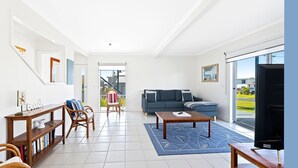 A modern living room with a sofa, coffee table, and a bookshelf. - 27 Harrison Street, Dalmeny (Dalmeny)