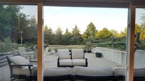 A patio with outdoor seating and a view of a garden.