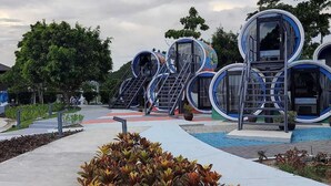 A modern building with circular structures and a central staircase. - Cocoons Club Laiya (San Juan)