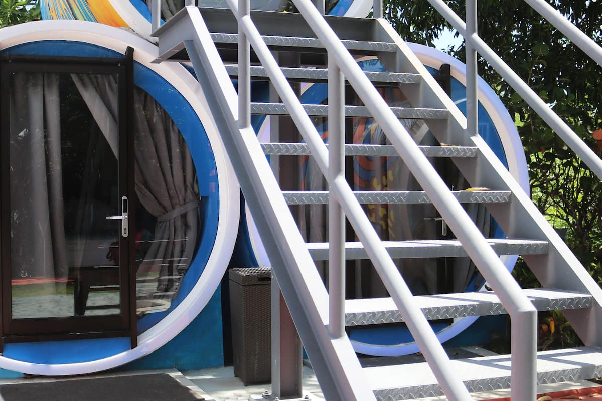 A circular structure with a glass door and a metal staircase.