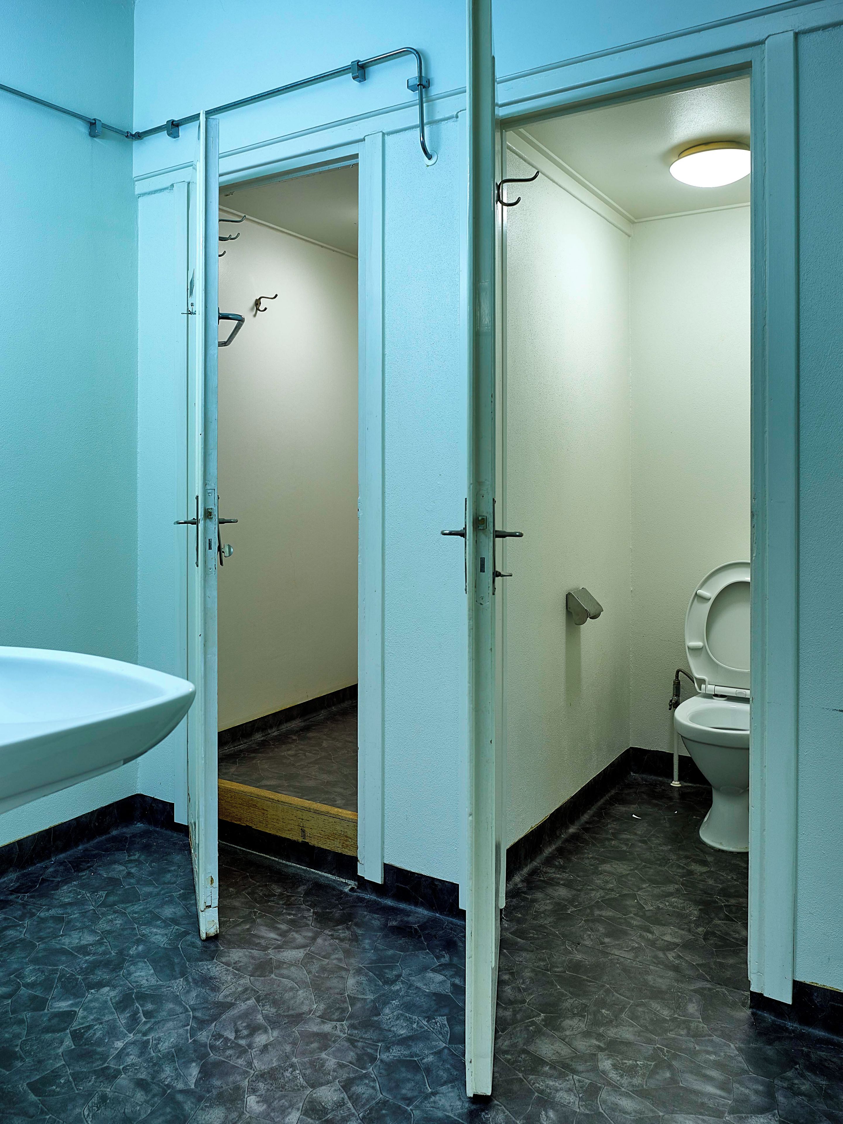 Ein Badezimmer mit einem weißen Waschbecken, einer Toilette und einer Duschkabine.