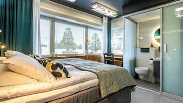Un dormitorio moderno con cama, escritorio y baño.