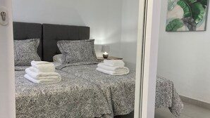 A modern bedroom with a bed, two pillows, a bedside lamp, and a wall-mounted artwork. - Stunning front line 2 bedroom apartment. (Tías)