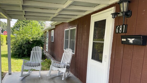 A house with a porch, two white Adirondack chairs, a welcome mat, and a mailbox with the number 681. - Pap's Place (Rockwood)