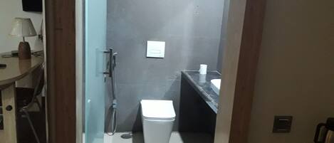 Ein kleines Badezimmer mit Toilette, Dusche und Waschbecken.