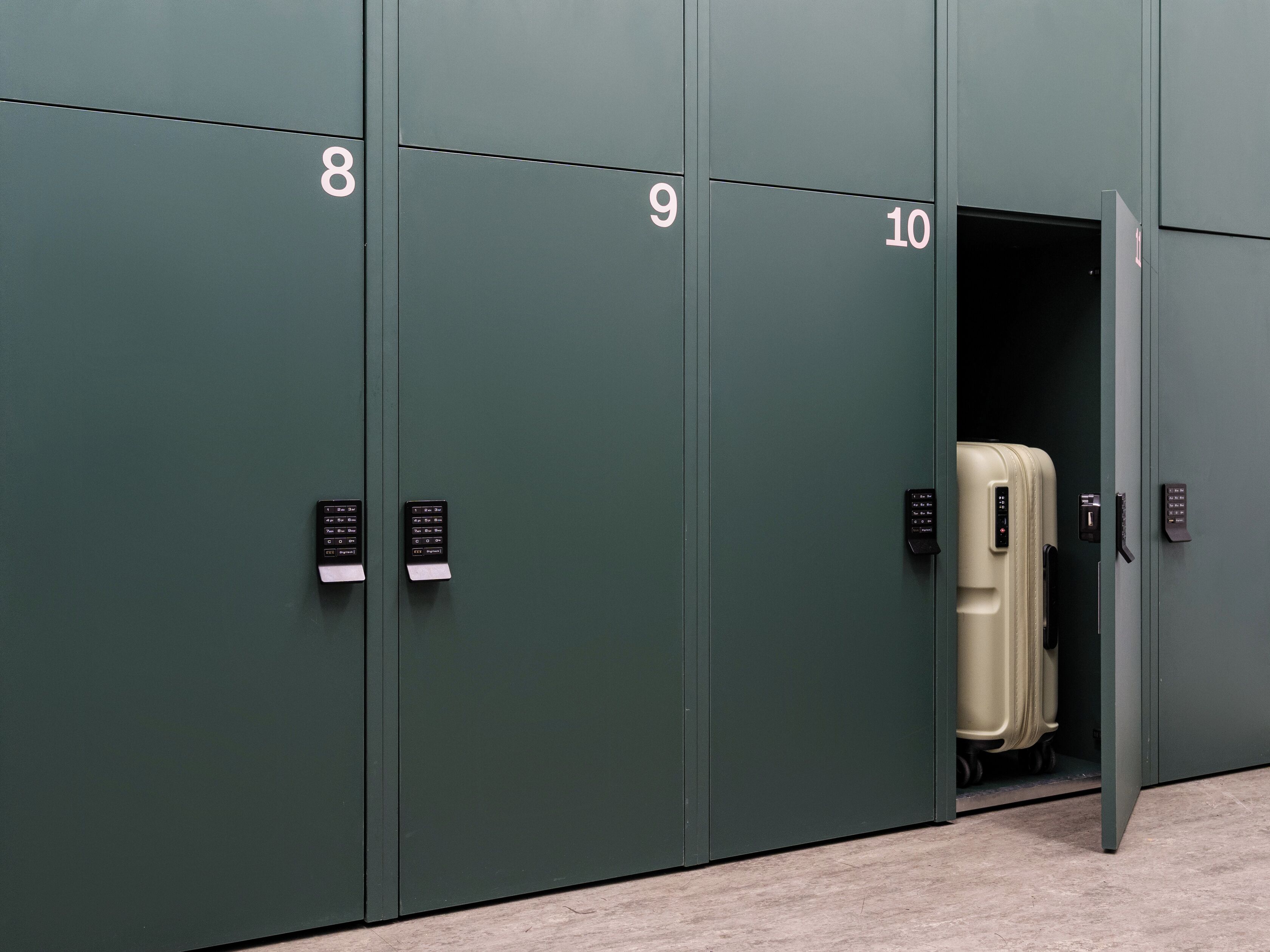 A row of green lockers numbered 8 to 10, each with a keypad lock.
