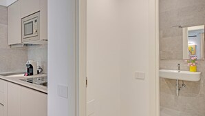 A modern kitchen with a built-in microwave, coffee maker, and a sink. - Right House Sur Le Port (CAGLIARI)