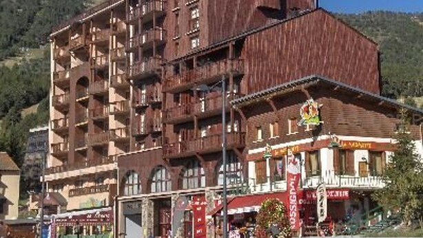 A multi-story building with balconies, a restaurant with outdoor seating, and a mountain backdrop. - Cozy 2* Apt, Ski-In/Out, Sleeps 4, Balcony, Parking, Near Hot Springs (Les Angles)