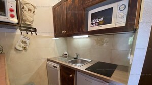 A compact kitchen with a microwave, sink, and a small refrigerator. - Cozy 2* Apt, Ski-In/Out, Sleeps 4, Balcony, Parking, Near Hot Springs (Les Angles)