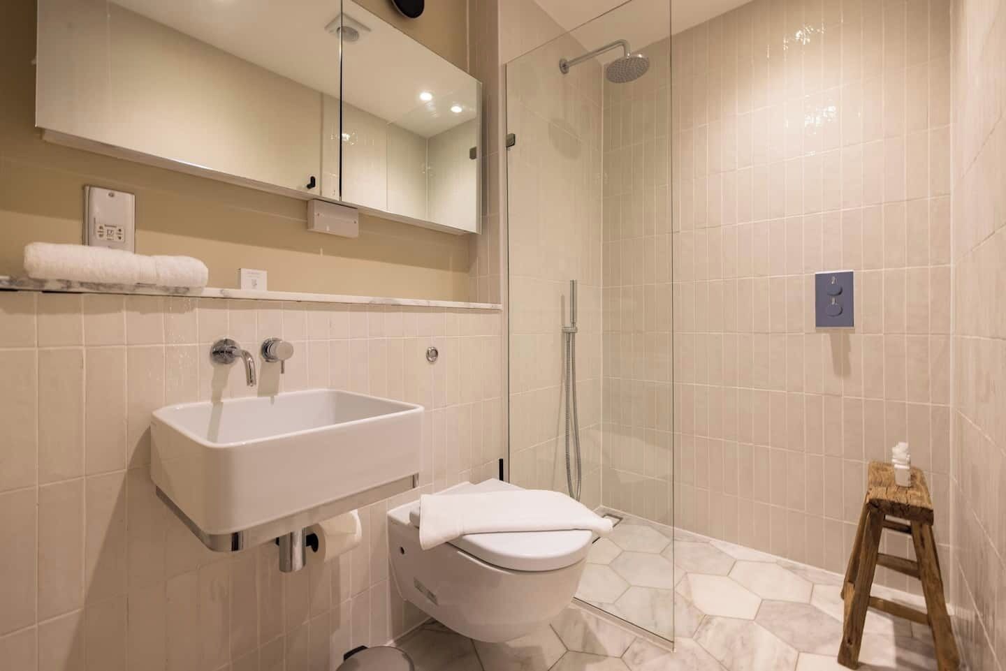 A modern bathroom with a sink, toilet, and shower.