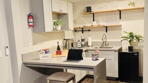 A modern kitchen with a central island, a built-in oven, and a refrigerator.