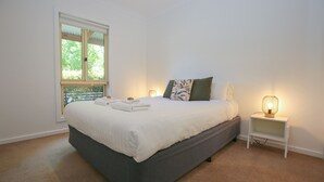 Una camera da letto con un letto, una finestra e lampade ai comodini.