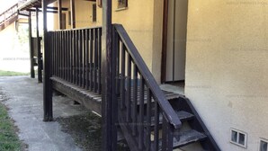 A wooden staircase leading to a building with a beige exterior and a window with bars. - 3* Chalet for 8, fireplace, parking, free shuttle (Les Angles)