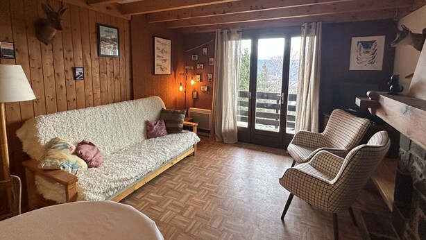 A cozy cabin interior with a wooden ceiling, a sofa, a chair, and a fireplace. - 3* Chalet for 8, fireplace, parking, free shuttle (Les Angles)