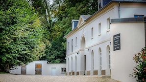 A building with a gravel courtyard, arched windows, and a signboard.