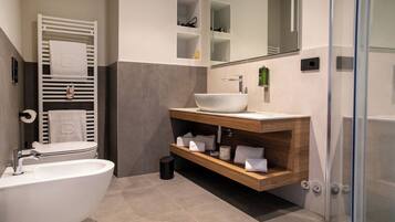 Un bagno moderno con una vasca da bagno indipendente, un mobile lavabo con un lavandino capiente e un box doccia in vetro.