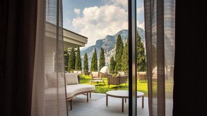 Un patio con mobiliario exterior, vista a montañas y un edificio al fondo.