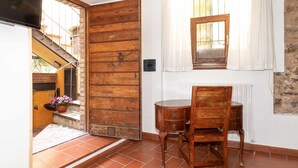 A room with a wooden door, a small table, and a chair.