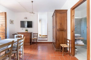 Un comedor con mesa y sillas de madera, un televisor montado en la pared y un mueble de madera.