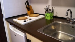 A kitchen with a stainless steel sink, a white dishwasher, a brown countertop, and a green utensil holder. - Bright studio in Pra Loup 1500 for 4/5 people, easy ski lift access (Pra-Loup)