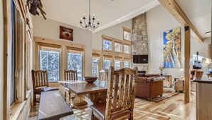 A spacious dining area with wooden furniture, large windows, and a stone wall. - Awesome Townhome just off Main Street in Frisco!! (Frisco)