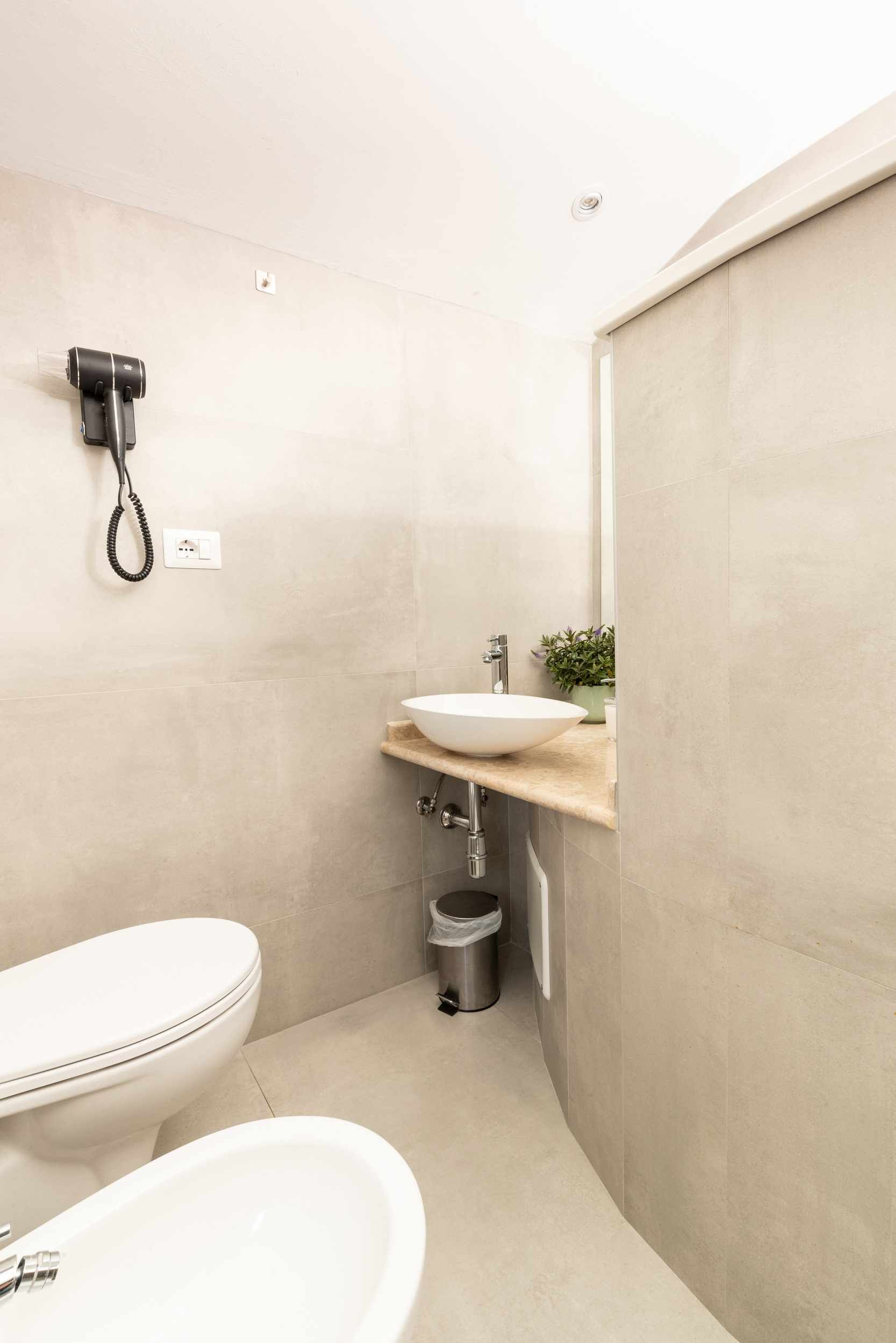 A modern bathroom with a toilet, bidet, and sink.