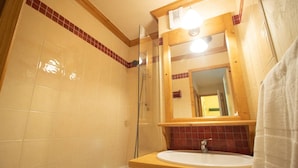 Un baño con bañera, lavabo, espejo y ducha.