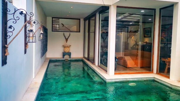A modern indoor pool with clear water, surrounded by glass walls and a minimalist design. - Villa Himala Bali (Seminyak)