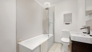 Une salle de bain moderne équipée d’une douche, de toilettes et d’un lavabo.