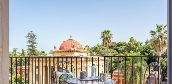Un balcon donnant sur un bâtiment historique, une table avec des chaises et un panneau indiquant qu’il s’agit d’un espace de travail moderne.