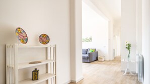 A bright, modern living room with a white wall, a wooden floor, and a grey sofa. - Un Balcone sull'Orto Botanico by Wonderful Italy (Palermo)