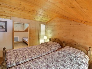 A cozy cabin room with two beds, a bunk bed, wooden walls, and a small window. - Charming Duplex 6 Pers, Pets Allowed, Méribel (Méribel)