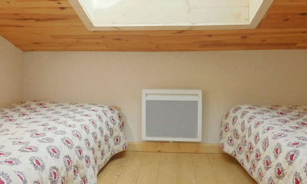 A room with two beds, a skylight, and a wall-mounted air conditioning unit. - Charming Duplex 6 Pers, Pets Allowed, Méribel (Méribel)
