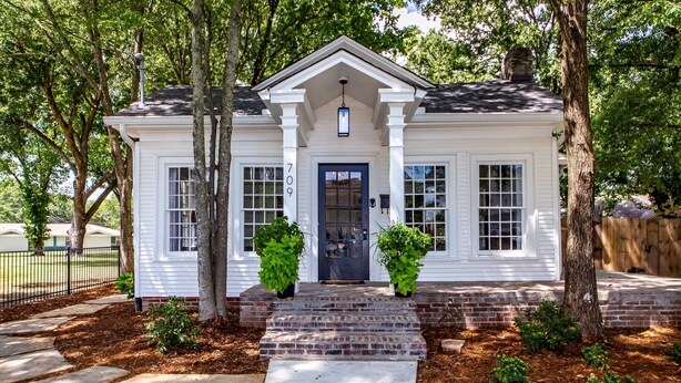 A white two-story house with a dark front door, a small porch with steps, and a mailbox. - Hip and Historic Home Awaits You!  Stroll downtown/Steps away from UCA and CBC (Conway)