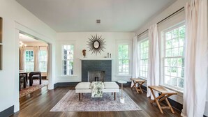 A spacious living room with a fireplace, a bench, and a coffee table. - Hip and Historic Home Awaits You!  Stroll downtown/Steps away from UCA and CBC (Conway)
