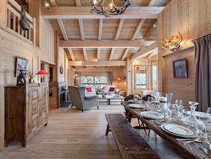 Cozy cabin-style accommodation with a dining table, sofa, and fireplace.