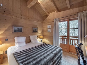 Relax in this serene bedroom with a large bed, bedside table, and stunning mountain view.