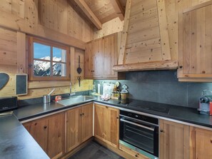 Enjoy a meal with a mountain view from this kitchen, featuring an oven, sink, and ample counter space.