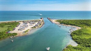 Vista aérea de una zona costera con un puerto deportivo, un estacionamiento y una playa.