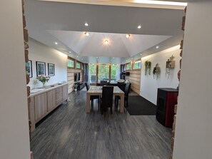 Een modern interieur met een eethoek, keuken en grote ramen.