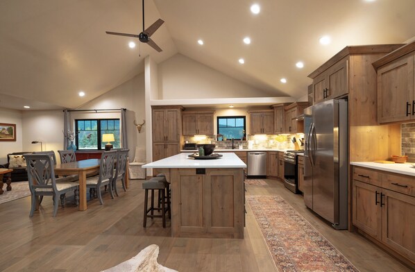 A spacious kitchen with wooden cabinets, a large island, and modern appliances.