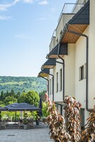 Un edificio con terraza al aire libre y vistas a un paisaje verde.