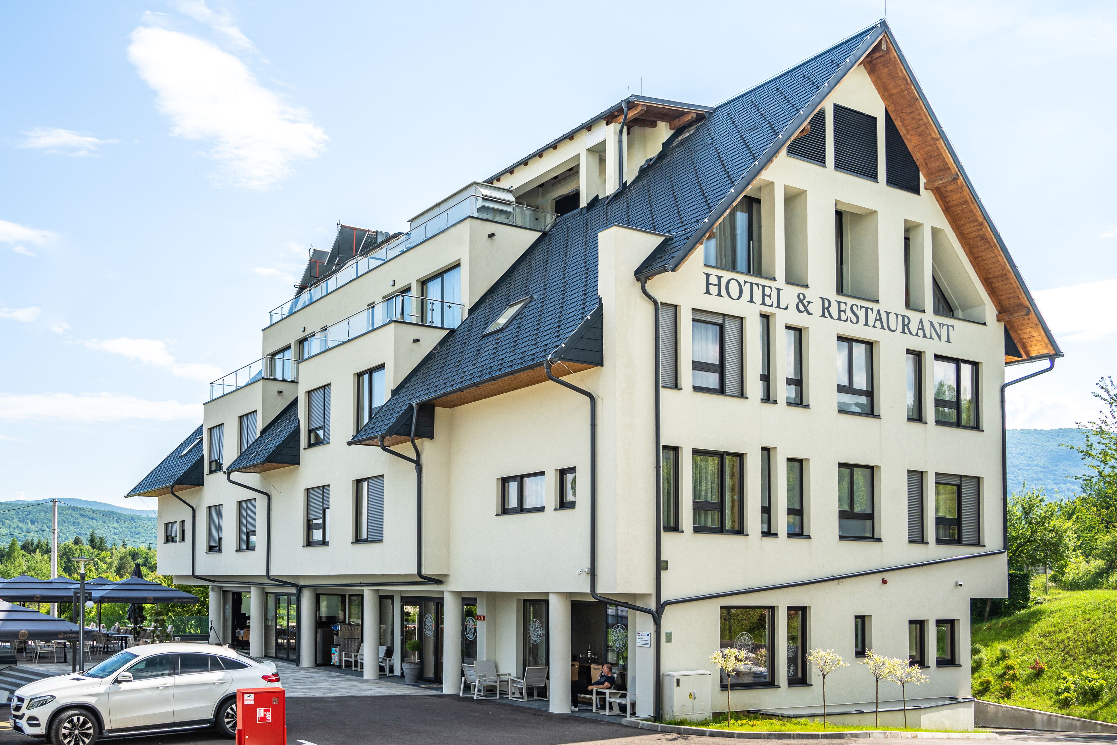 Un hotel de varios pisos con un diseño moderno, que presenta un letrero llamativo que dice 'HOTEL & RESTAURANT'.