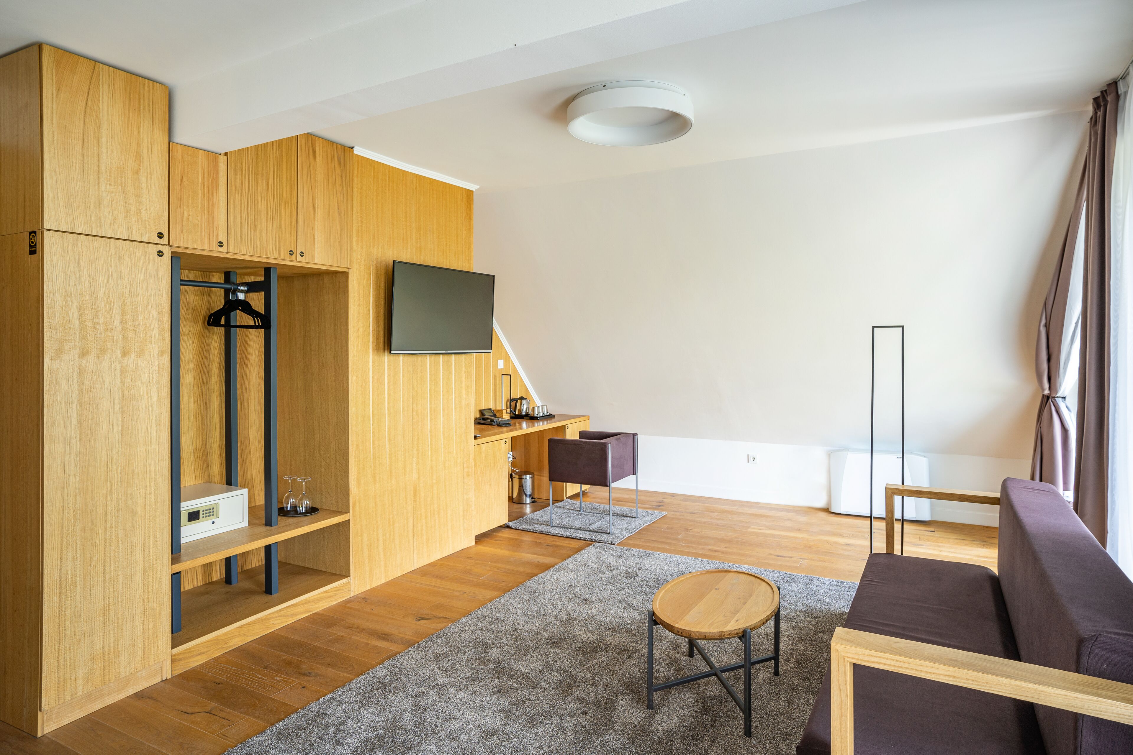Una sala de estar moderna con muebles de madera, un televisor de pantalla plana y un sofá.