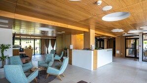 A modern reception area with a wooden ceiling, a reception desk, and seating arrangements. - Hotel Palcich (Rakovica)