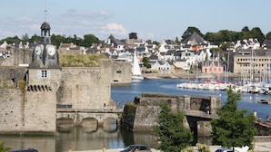 A historic stone tower with a clock, a bridge, and a waterfront with boats. - ❤️ New! Luxury apartment with sea view in the heart of downtown (Concarneau)