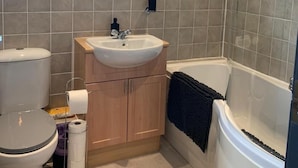 A bathroom with a toilet, sink, and bathtub. - The Rabbit Hole - Kinlochbervie (Kinlochbervie)